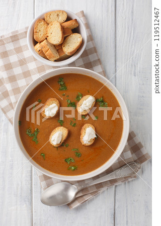 Tasty Soupe de poisson French soup with white fish simmered in a light vermouth stock with croutons and aioli sauce closeup on the bowl. Vertical top view Tasty Soupe de poisson French soup with white fish simmered in a light vermouth stock with croutons and aioli sauce closeup on the bowl. Vertical top view 119512467