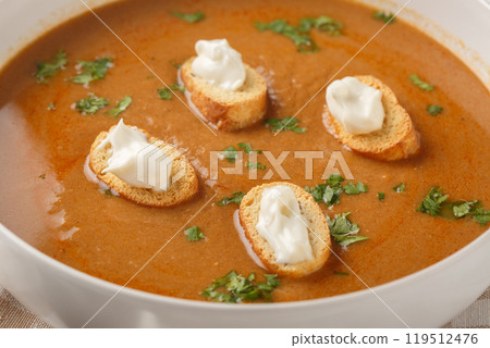 Tasty Soupe de poisson French soup with white fish simmered in a light vermouth stock with croutons and aioli sauce closeup on the bowl. Horizontal 119512476