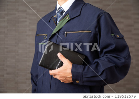 穿著工作服的中年男性商人拿著黑色皮革筆記本 穿著工作服的中年男性商人拿著黑色皮革筆記本 119512579