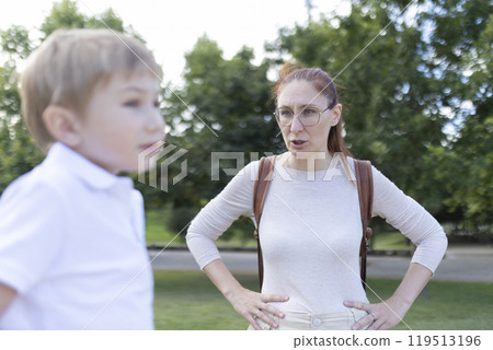 A woman is talking to a young boy in a park 119513196