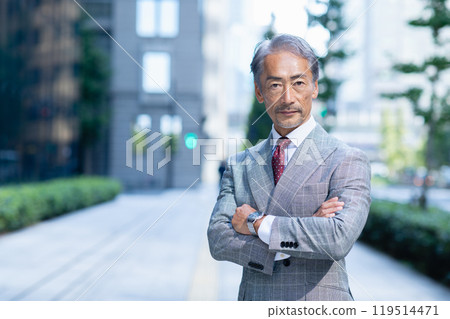 Senior businessman with his arms folded in an office district 119514471