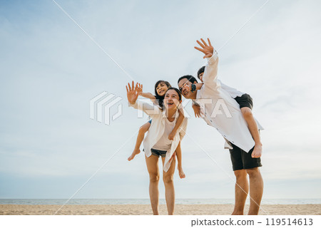 Joyful family on vacation at the beach. Parents with children laughing playing and enjoying the sun. Summer holidays depict happiness fun and freedom. Travel and family enjoyment Joyful family on vacation at the beach. Parents with children laughing playing and enjoying the sun. Summer holidays depict happiness fun and freedom. Travel and family enjoyment 119514613