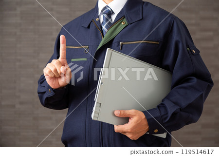 一位穿著工作服的中年男性商人拿著活頁夾文件並舉起食指 一位穿著工作服的中年男性商人拿著活頁夾文件並舉起食指 119514617