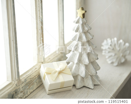 Christmas tree and gift boxes placed on a bright windowsill 119515401