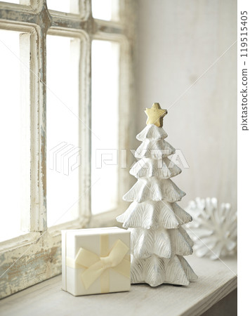 Christmas tree and gift boxes placed on a bright windowsill Christmas tree and gift boxes placed on a bright windowsill 119515405