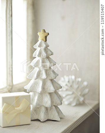 Christmas tree and gift boxes placed on a bright windowsill 119515407