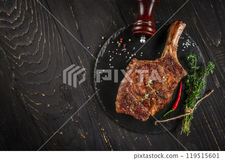 rib eye Tomahawk beef veal steak on a dark background. top view. copy space for text 119515601