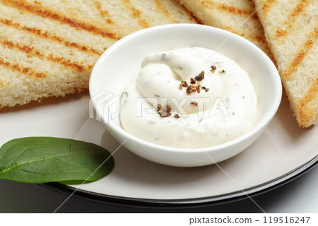 Cup with cheese sauce on the kitchen table. 119516247