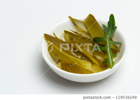 Pickled cucumbers in the white ceramic bowl. 119516249