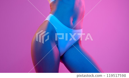 Close-up of woman's torso with smooth, glowing skin, highlighting fitness and body curves in vibrant blue-pink neon light. Close-up of woman's torso with smooth, glowing skin, highlighting fitness and body curves in vibrant blue-pink neon light. 119517598