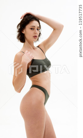 Portrait of young attractive woman posing holding hand on head and looking at camera, shoeing confidence against white studio background. Portrait of young attractive woman posing holding hand on head and looking at camera, shoeing confidence against white studio background. 119517735