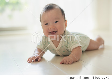 Baby lying on the windowsill 119517737