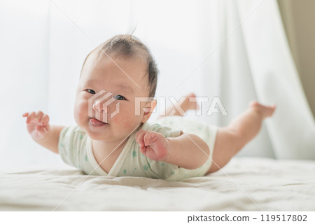 Baby lying by the window, airplane pose Baby lying by the window, airplane pose 119517802