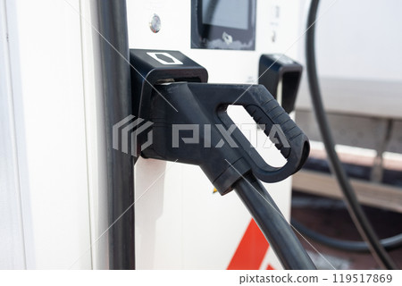 e-car charging station, e-car charge point or electric vehicle supply equipment (EVSE) with information sign electric car public charging point station and charge cable, charging plug parking spaces 119517869