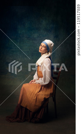 Cinematic portrait of elegant young woman wearing vintage-inspired clothes. Girl with white pearl against dark vintage background. Cinematic portrait of elegant young woman wearing vintage-inspired clothes. Girl with white pearl against dark vintage background. 119517889