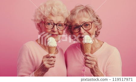 Elderly women eat ice cream cones on a pink background 119517971