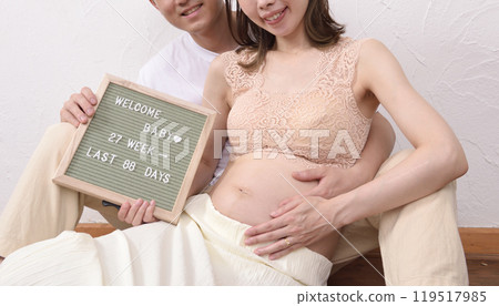 一位年輕的孕婦和她的丈夫擁抱 119517985