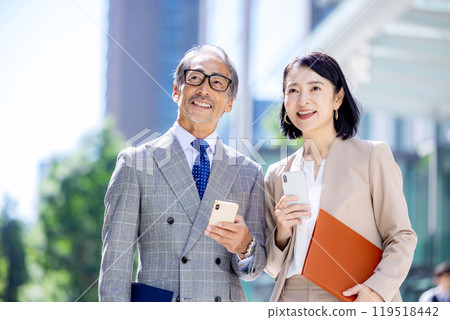 Senior office worker in an office district holding a smartphone 119518442
