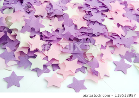 Colorful star-shaped confetti scattered on a white surface, perfect for celebrations, parties, or 119518987