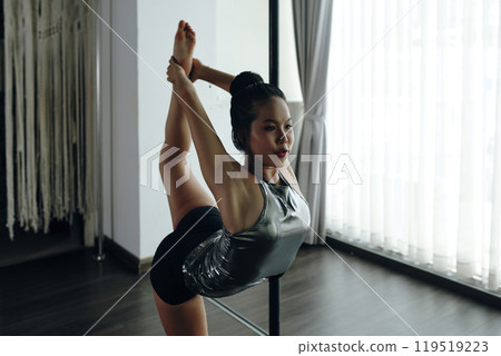 Practicing Advanced Yoga Pose in Modern Studio Practicing Advanced Yoga Pose in Modern Studio 119519223