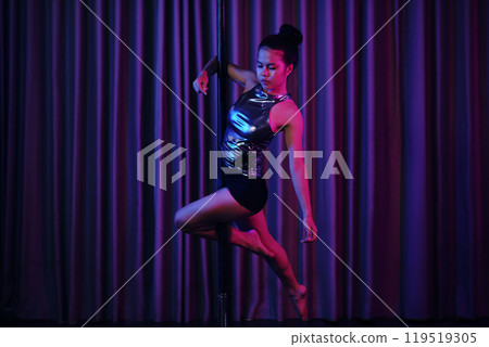 Graceful Performer Executing Pole Dance Routine 119519305