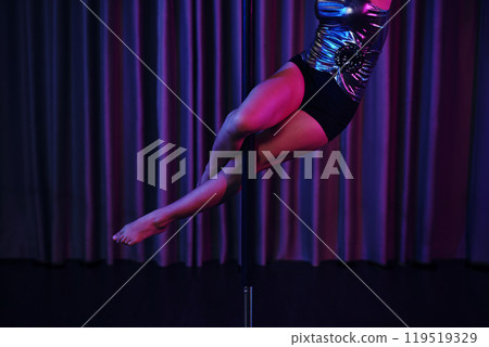 Performing Graceful Pole Dance in Dimly Lit Room Performing Graceful Pole Dance in Dimly Lit Room 119519329