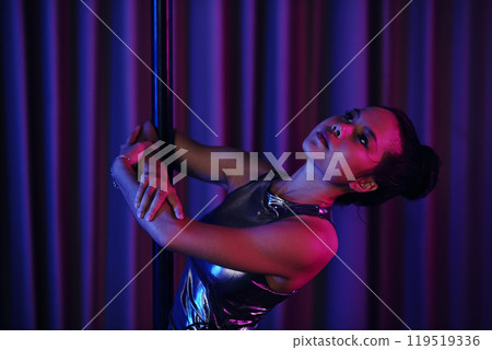 Twirling Around Pole with Dramatic Lighting Effects 119519336