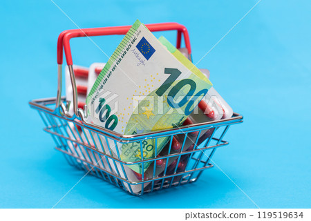 Pills and Capsules in Shopping Basket on Blue Background 119519634