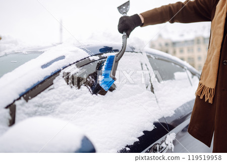 Transport, winter, weather, people and vehicle concept - young man cleaning snow from car with brush Transport, winter, weather, people and vehicle concept - young man cleaning snow from car with brush 119519958
