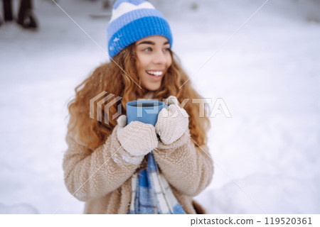 Young woman drinking a hot drink outdoors. Adventure concept. Lifestyle. 119520361