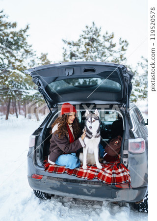 Young woman and cute husky dog enjoying outdoors into the car. Travel concept. Winter season. 119520578