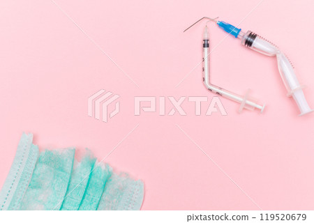 Broken Medical Syringe and Torn Medical Face Mask on the Pink Background 119520679