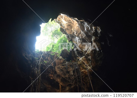 stalagmites and stalactites with sunlight through cave hole in Khao Luang cave travel location on Thailand 119520707