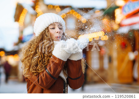 Close up Hands in warm mittens make snow in winter. Happy young woman in snowy winter park. Close up Hands in warm mittens make snow in winter. Happy young woman in snowy winter park. 119520861