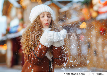 Close up Hands in warm mittens make snow in winter. Happy young woman in snowy winter park. Close up Hands in warm mittens make snow in winter. Happy young woman in snowy winter park. 119520862