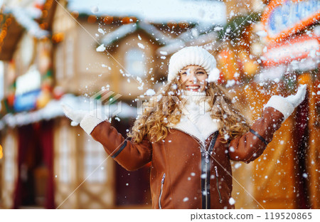 Beautiful woman walking between decorated stalls or kiosks in Christmas market. Travel concept. Beautiful woman walking between decorated stalls or kiosks in Christmas market. Travel concept. 119520865