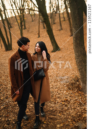 Young couple in love walking in the park on a autumn day. Enjoying time together. 119521167