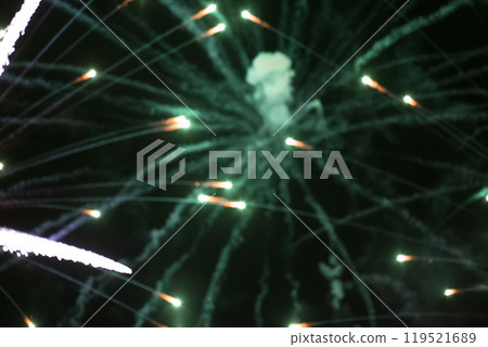 Green rays from the explosion of fireworks with smoke spots. Green rays from the explosion of fireworks with smoke spots. 119521689