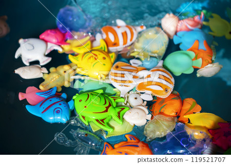 Toy colorful fish in blue water. 119521707