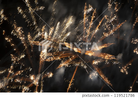 Blurred golden fireworks lights on a black background. 119521786