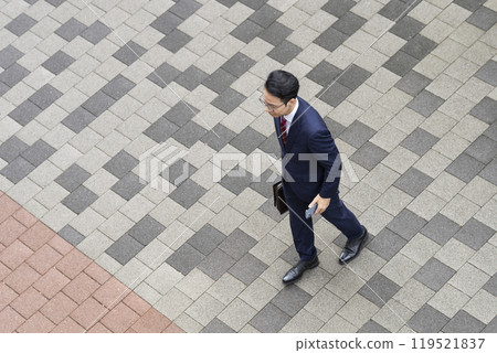 Aerial view of a middle-aged businessman walking in the city 119521837
