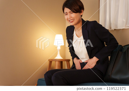 A female businessman who has abdominal pain at night (menstrual pain, suit) 119522371