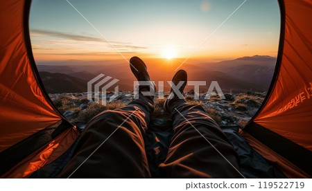 A person peacefully lays in a tent on a stunning mountain at sunset A person peacefully lays in a tent on a stunning mountain at sunset 119522719