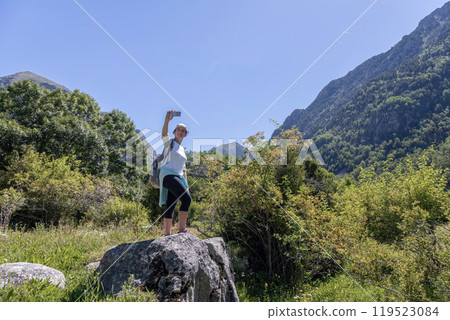 Young pretty tourist woman with backpack take a picture with mobil in the mountain 119523084
