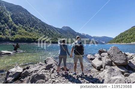 Tourist couple looking at the lake of mountain Pyrenees in Catalonia of Spain 119523088