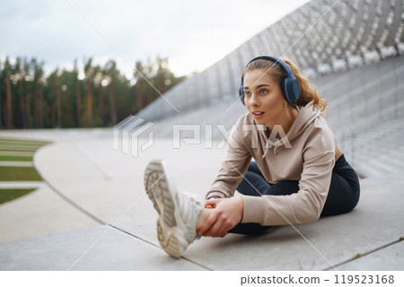 Sports woman in sportswear does exercises outdoors. . Sport, active lifestyle, healthy lifestyle concept. 119523168