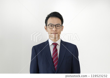 A businessman in his late 30s wearing glasses looking at the camera 119523232