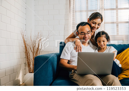 Modern family time on the couch parents and kids with a laptop. A young man woman son and daughter find happiness in their togetherness education and online connections. 119523353