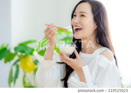Woman eating yogurt 119525023