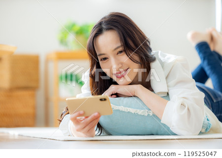 年輕女子在客廳看智慧型手機 119525047
